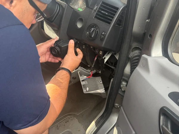Professional auto locksmith repairing a faulty ignition barrel and ignition lock on-site.